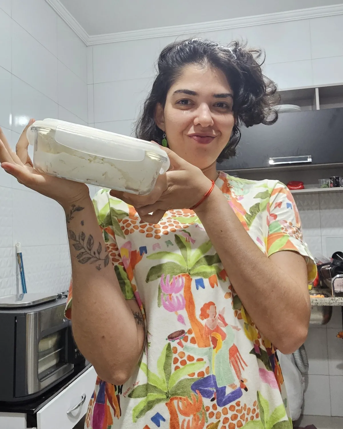 Rafa na cozinha segurando um recipiente com labneh.